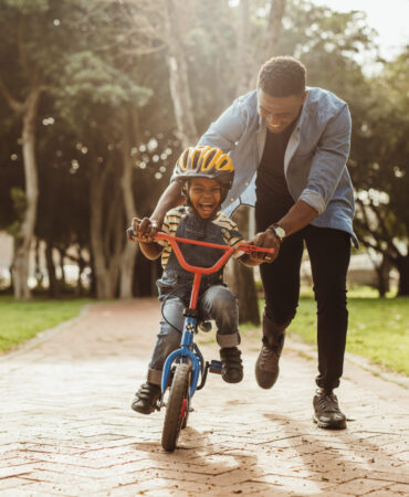 Boy,Learning,To,Ride,A,Bicycle,With,His,Father,In